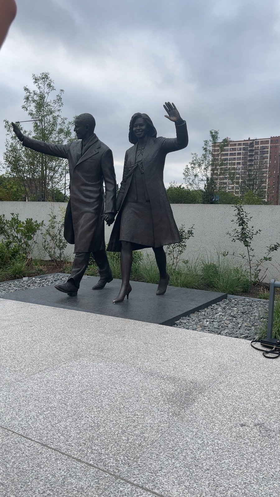 Sculpture of a couple waving in an outdoor garden